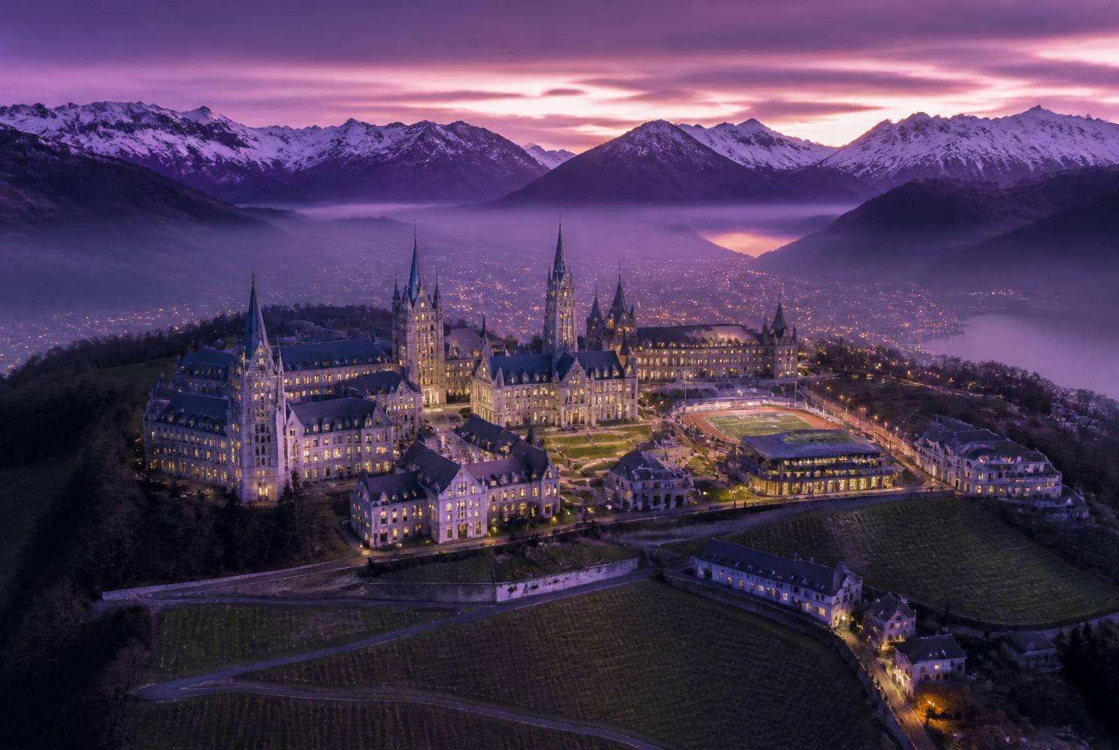 Aerial view of the St. Estè University campus and the Alps beyond